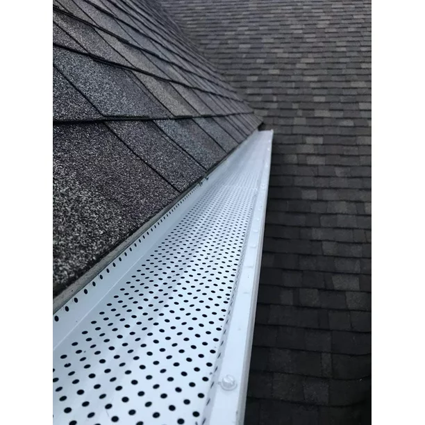 View of roof shingles and metal gutter along the roof edge, with shingles on the left and right sides.
