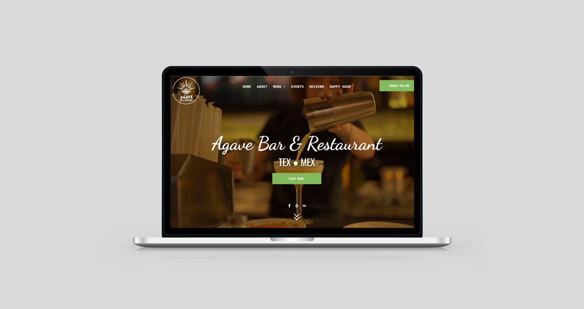 Laptop displaying a bar and restaurant website with a drink glass and text overlay.