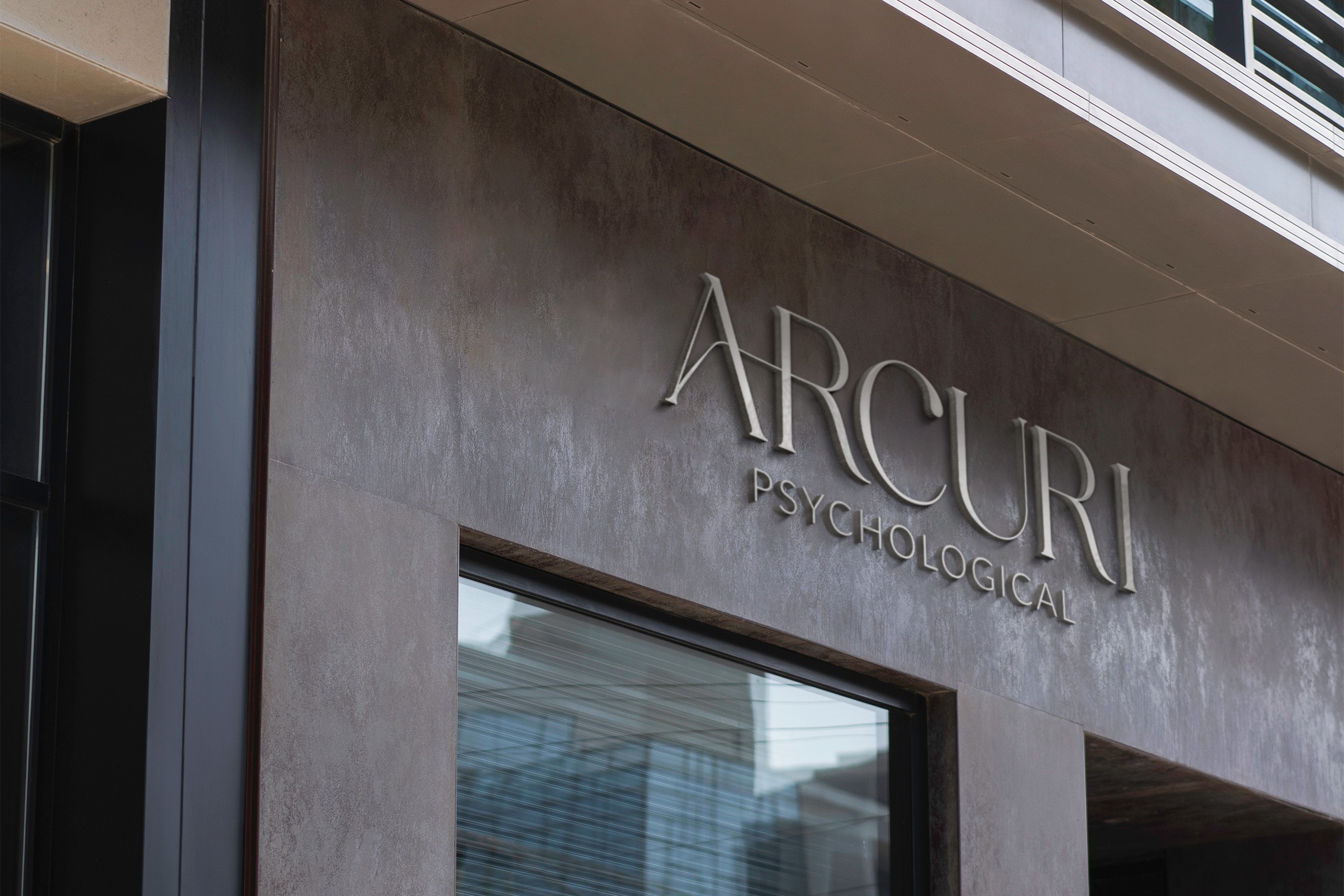 Building exterior with sign reading 'ARCURI PSYCHOLOGICAL' above a window.