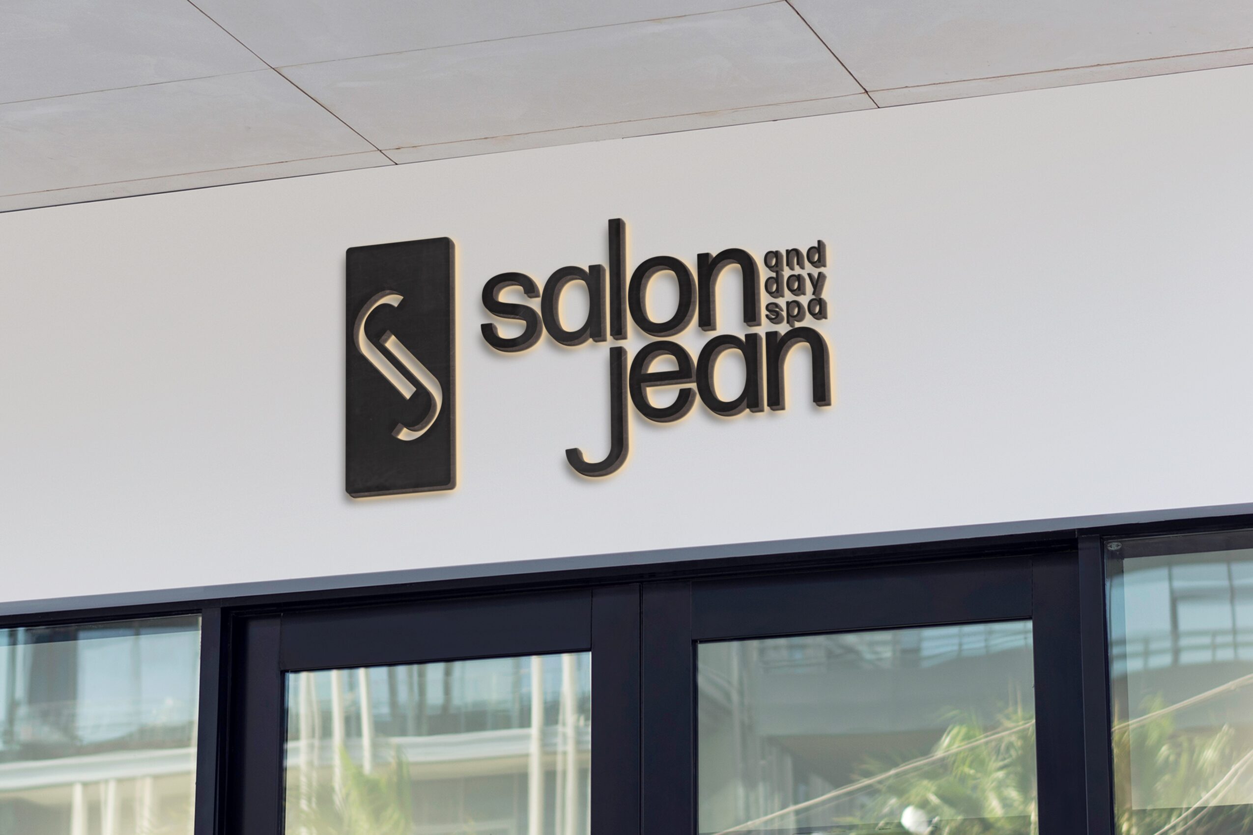 Salon and Jean sign on wall with logo and text, glass door below, interior visible through glass