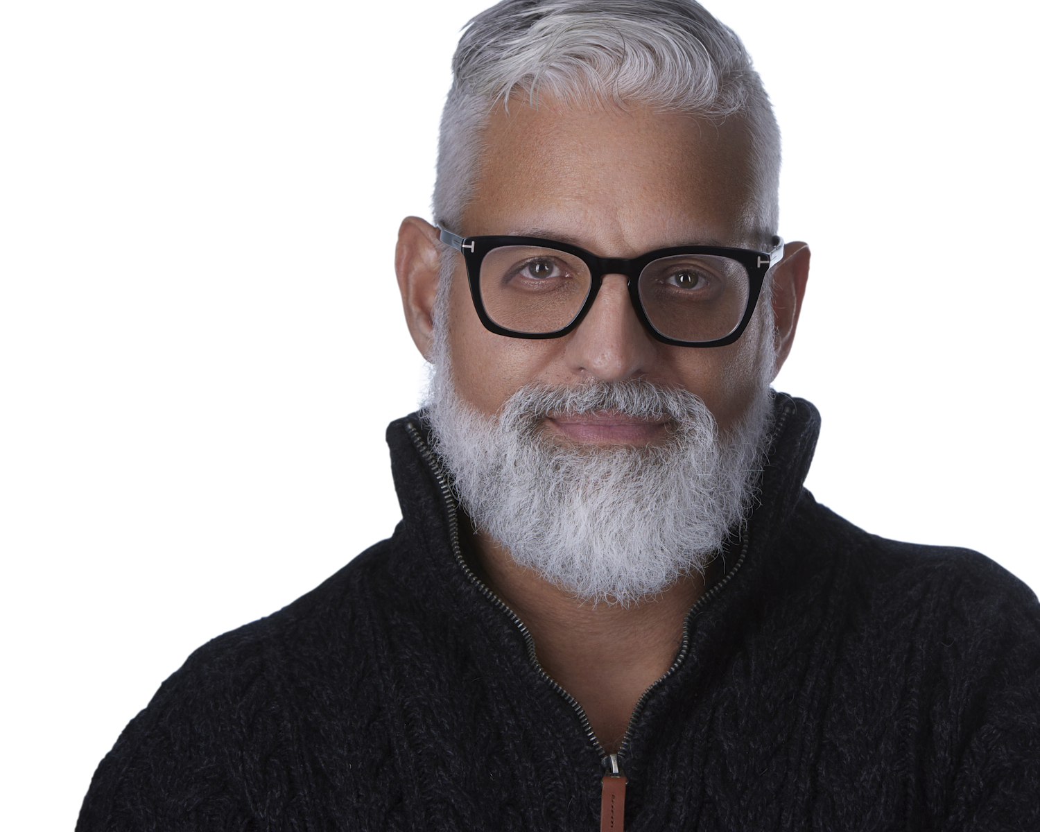Portrait of a mature man with white hair and beard, wearing glasses and a black sweater, smiling.