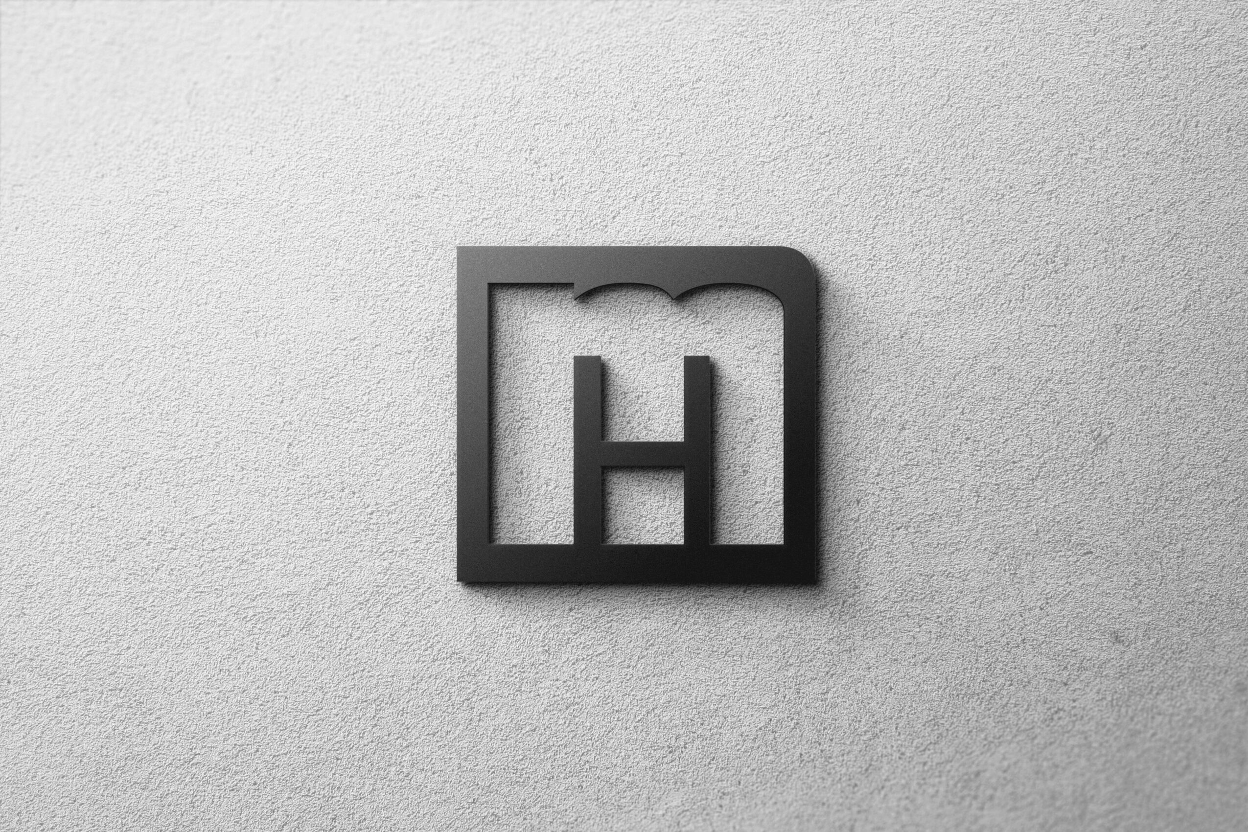 Black letter H inside a square frame on a light gray textured background.